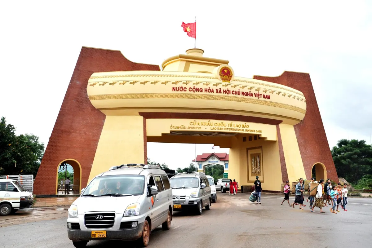 Passenger vans driving out through the Lao Bao border gate